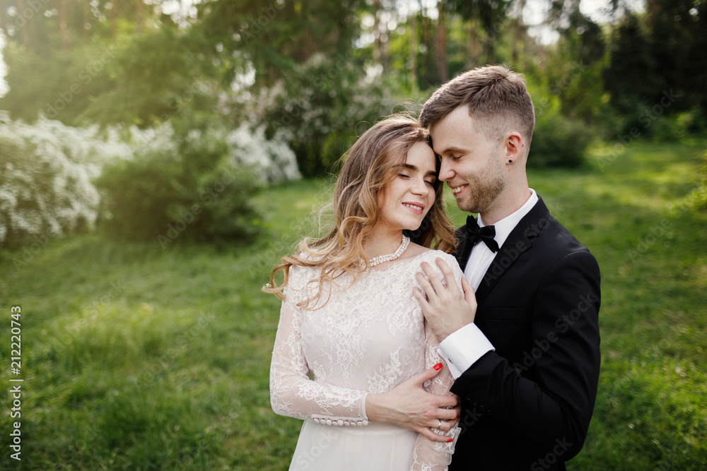 Elegant gorgeous bride and stylish groom posing in the park. Elegant gorgeous bride and stylish groom posing in the park.