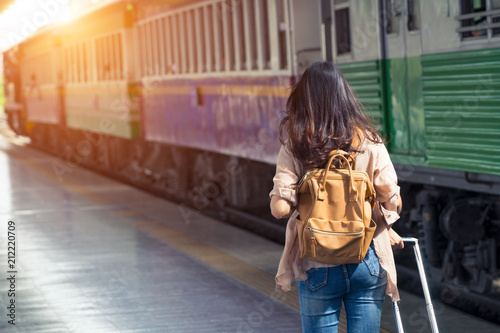 Woman traveler tourist walking with luggage at train station. Active and travel lifestyle concept