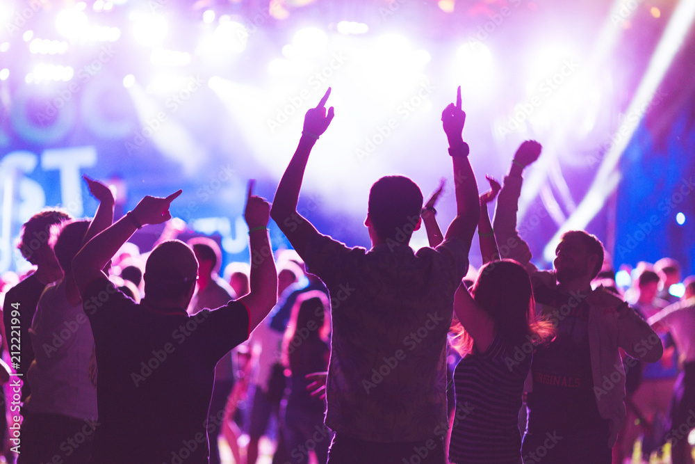 Bright colorful background with the silhouettes dancing young people during the performance favorite musician. Bright colorful background with the silhouettes dancing young people during the performance favorite musician.