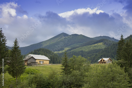 Photo of mountain village in the summer under beautiful cloudy sky. Ukraine, Carpathians, Dzembronia