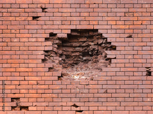 Echoes of war. Wall damaged by a military projectile  bomb   broken red brickwork. Brest fortress  exterior  fortification