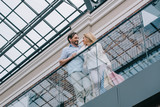 low angle view of couple standing on balcony in shopping mall