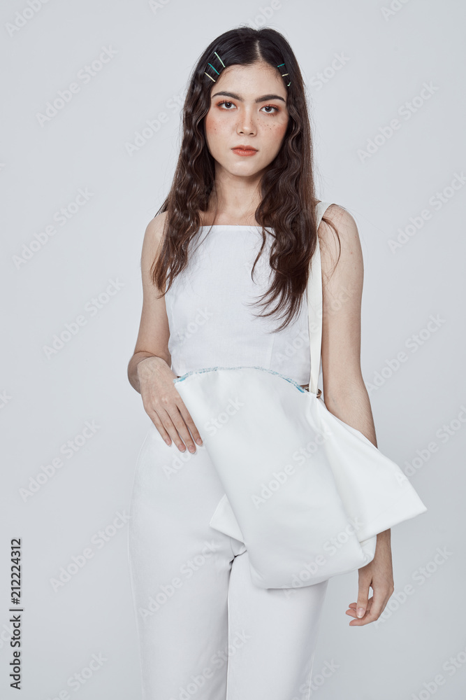 Beautiful happy woman holding a bag in studio. Beautiful happy woman holding a bag in studio.