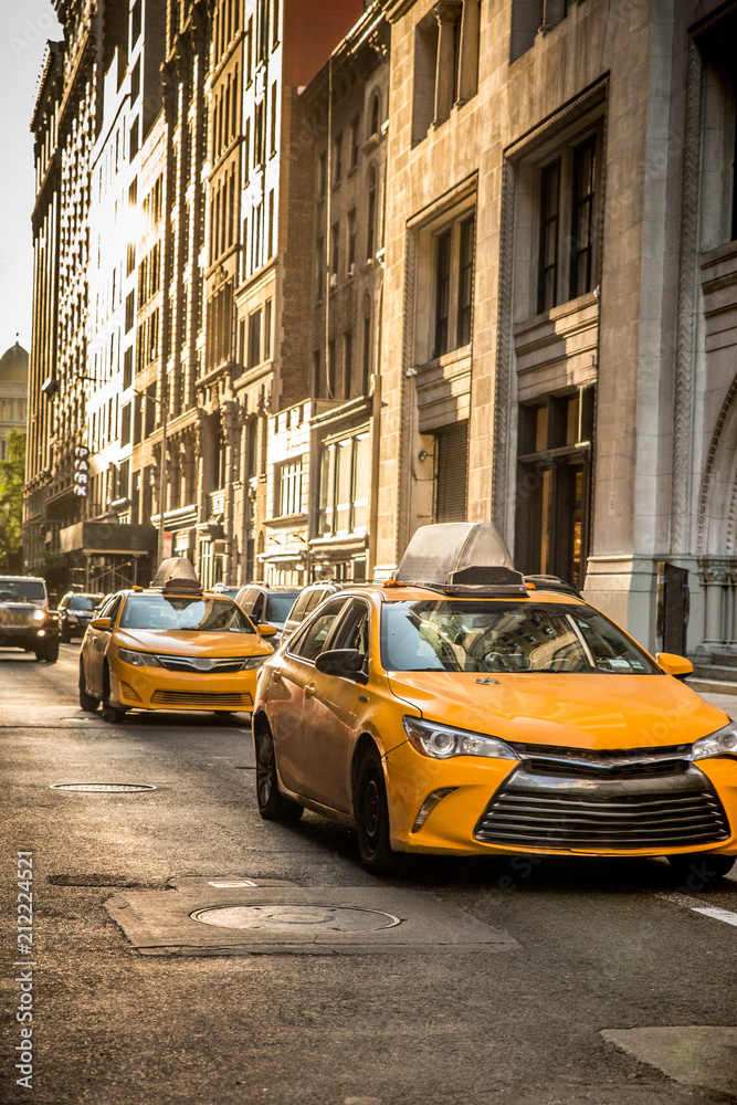 Fototapeta Uliczny widok w Miasto Nowy Jork w środku miasta Manhattan z żółtymi taxi taksówkami i budynkami.