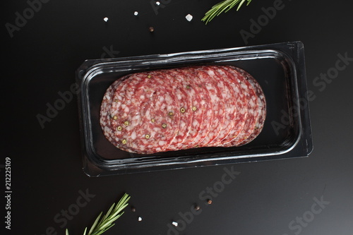 sausage sliced in a package on a dark background