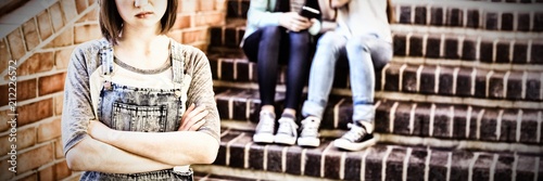 School friends bullying a sad girl in school corridor