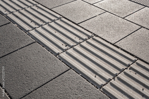 Line of hazard warning tactile paving along the edge of platform at the train station. Tactile paving assists visually impaired pedestrians and warns them of danger ahead. photo