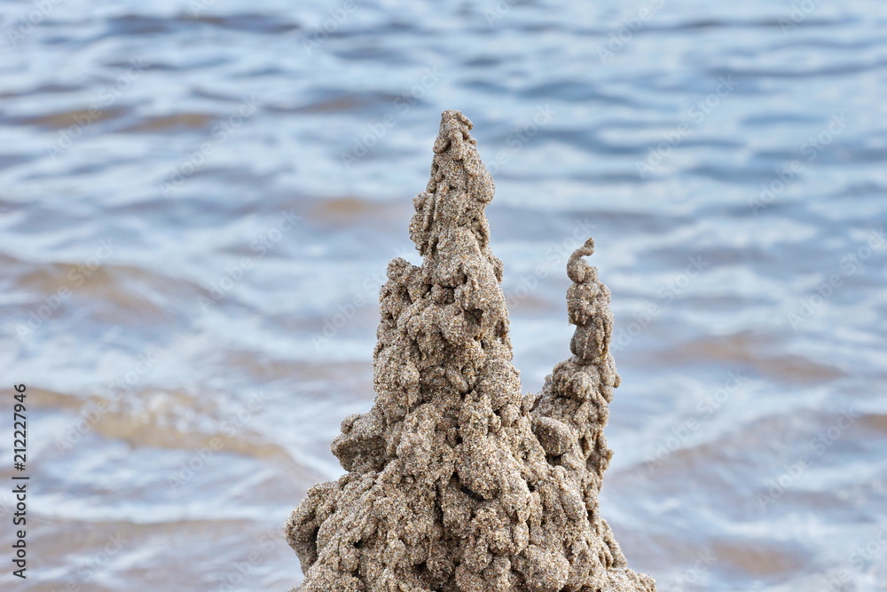sand castle on the beach against the water sand castle on the beach against the water