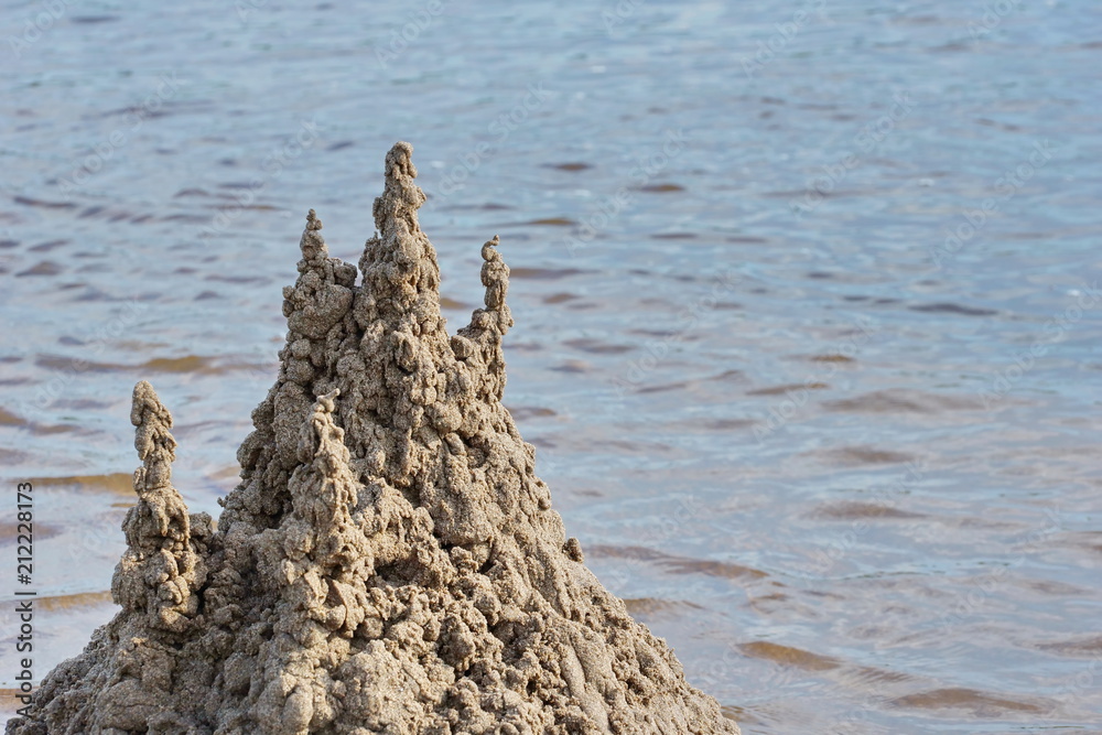 sand castle on the beach against the water sand castle on the beach against the water