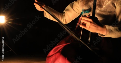 Korean female musician playing the Haegeum which is the Korean traditional string instrument on stage photo