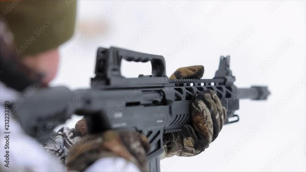 A Close up view of the man with rifle. The man in camouflage targets and shoots with a tactical rifle A Close up view of the man with rifle. The man in camouflage targets and shoots with a tactical rifle