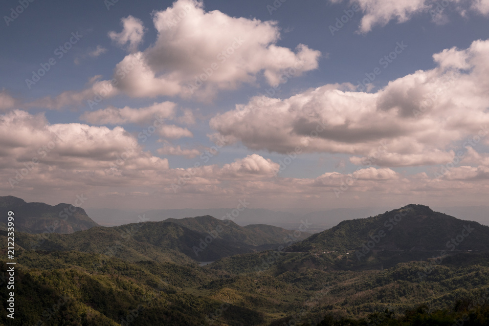 landscape view of green mountains under white clouds and blue sky in Thailand