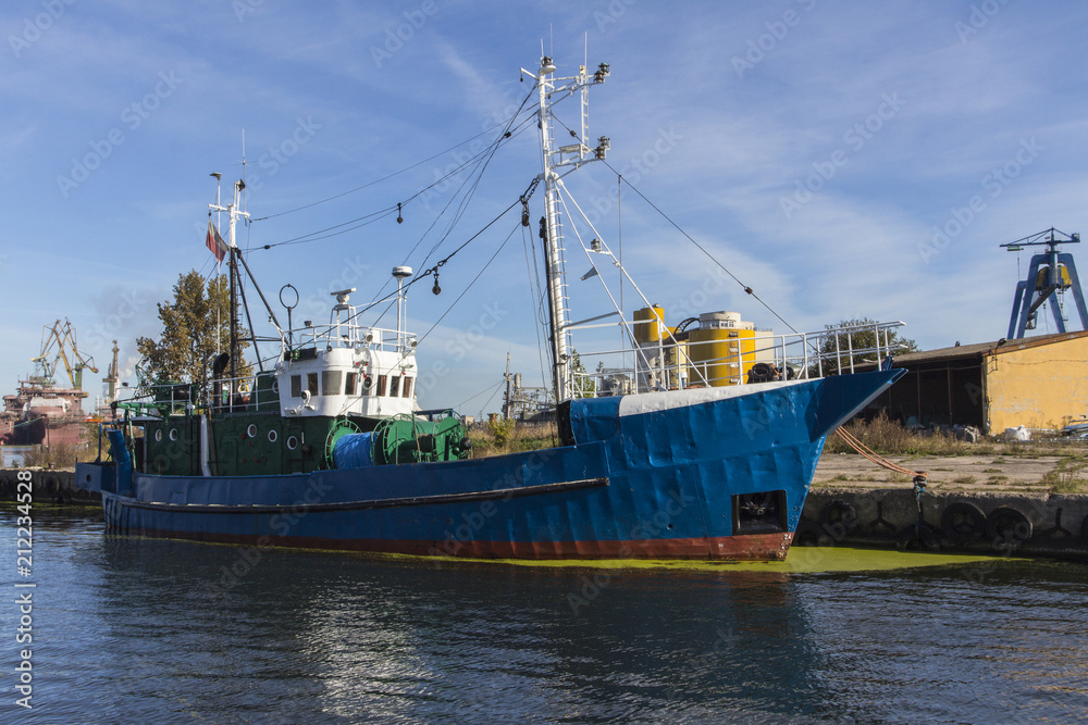 Old blue ship at the pier of the sunny day.