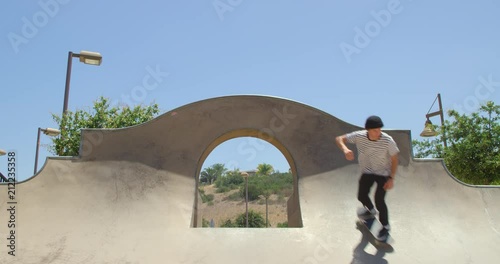 Man skateboarding does extreme grind over quarter pipe 