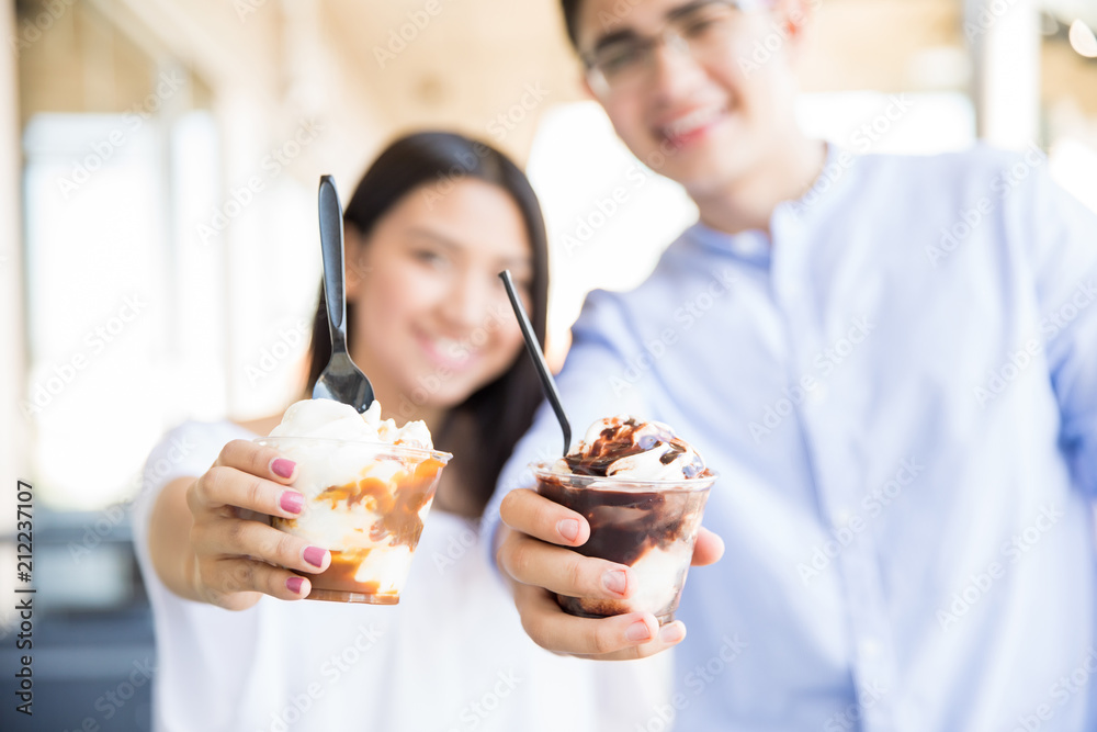 Defocused Couple Showing Icecream In Mall Defocused Couple Showing Icecream In Mall