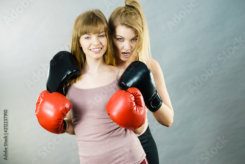 Two women friends wearing boxing gloves