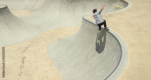 High angle of man skateboarding grinding pool coping 