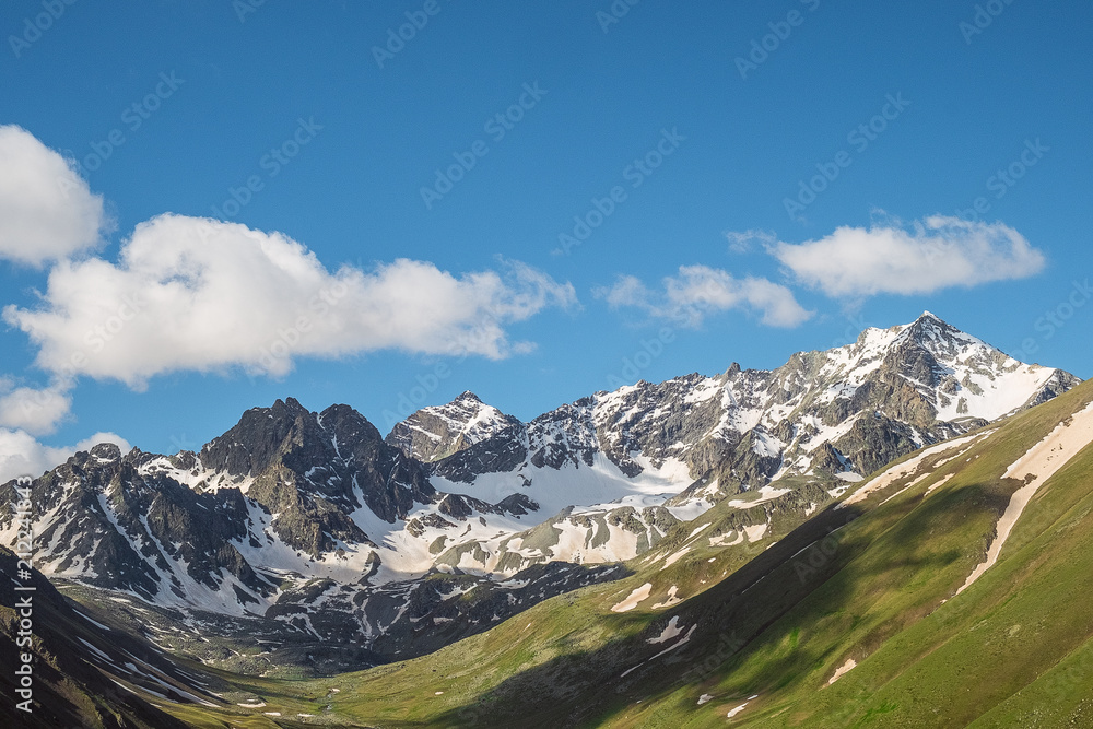 mountain valley overgrown with green grass with the remains of snow on the slopes of the mountain peaks landscape illustration background