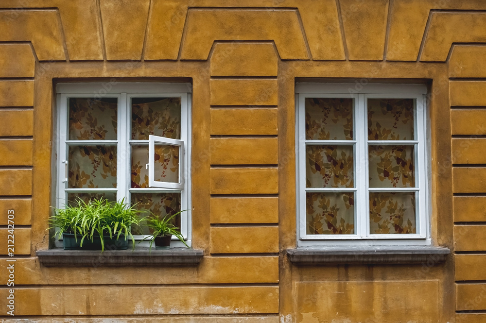old beautiful town houses; Sights of Warsaw;colorful houses with windows;windows with white frames in a yellow wall