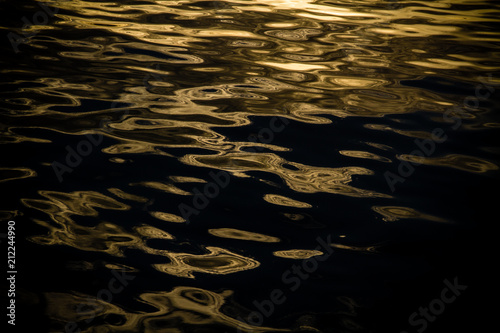 The water ripples reflection sunset lights on the ocean water surface