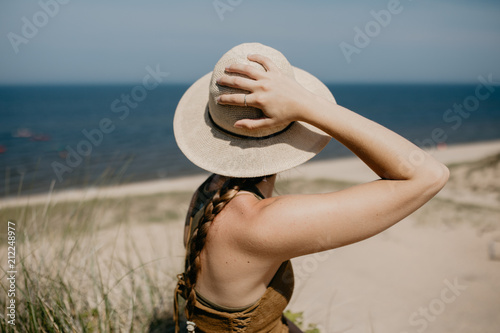 Woman wearing a sunhat on the beach in summer