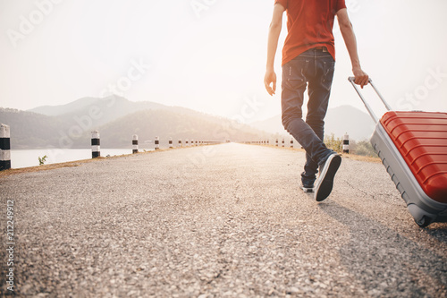 Travel concept. Men wear sneakers shoes and travel with luggage on the street.