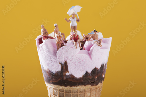 miniature people in swimsuit on an ice cream.