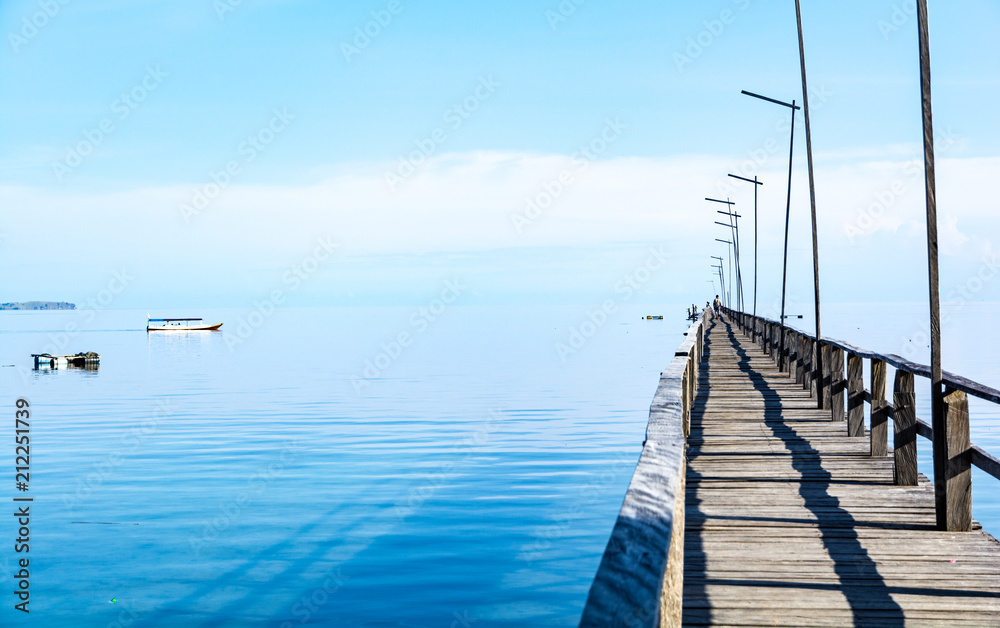 Obraz premium A Long Wooden Pier on Clear Turquoise Water with Endless Sea in Flores Island, Labuan Bajo, Indonesia