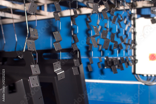 spare parts are hanging for painting. powder painting. stainless steel. metal working.