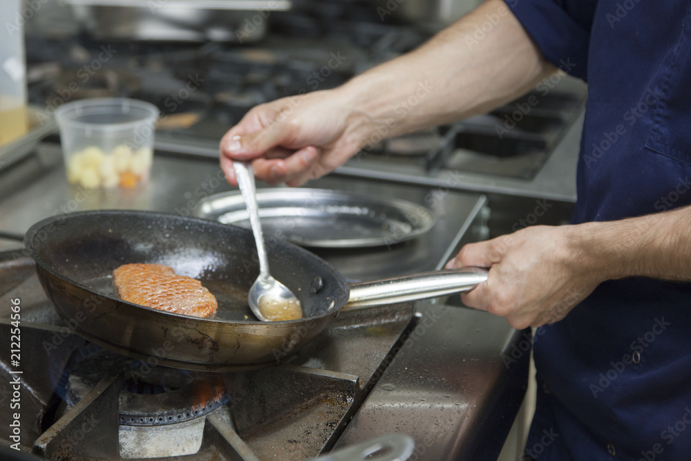 The cook fry the duck fillet in a frying pan. Gas hob The cook fry the duck fillet in a frying pan. Gas hob