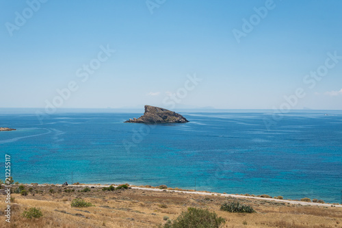 A shark fin shaped rock across Κomito beach at Syros greek island, Cyclades, Greece