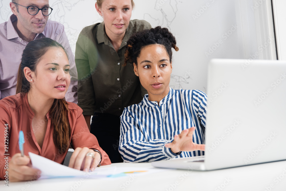 Fototapeta premium Business team looking at a laptop and gesturing