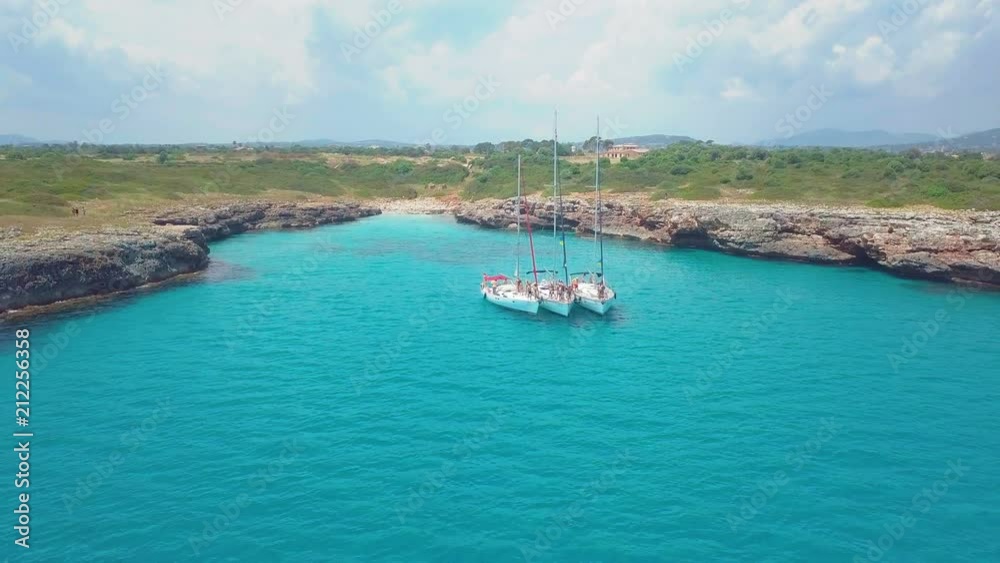 Top view of the sailing boats in blue lagoon. Swimmers enjoying in clear blue sea. Top view of the sailing boats in blue lagoon. Swimmers enjoying in clear blue sea.