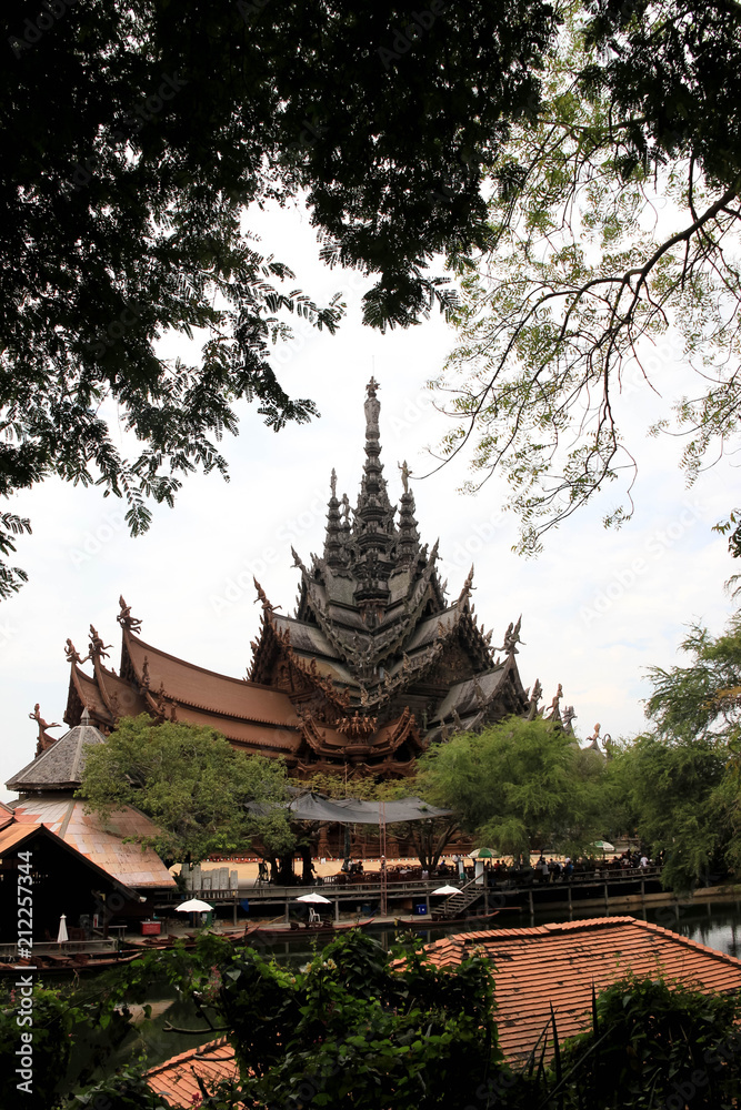 The modern construction of the temple of truth in Thailand against the background of green trees The modern construction of the temple of truth in Thailand against the background of green trees