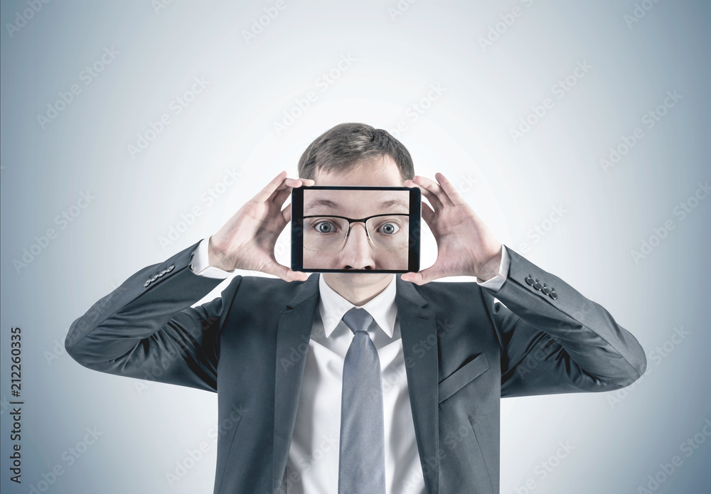Businessman with his face zoom in on tablet screen Businessman with his face zoom in on tablet screen