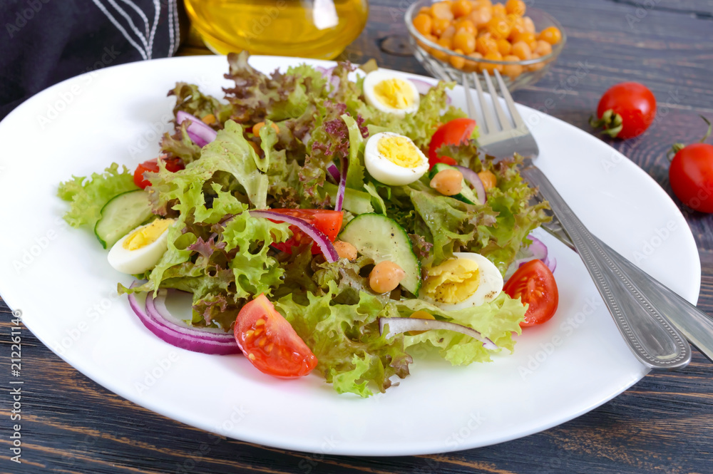 Light summer salad with fresh vegetables, greens, quail eggs and chickpeas. Vegetarian dish. Proper nutrition. Close-up.