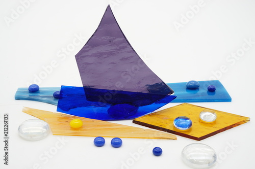 Color shattered glass pieces and small glass balls on white background