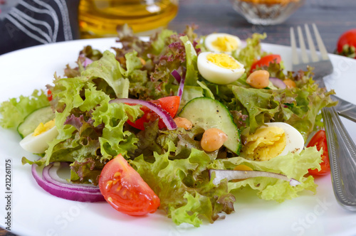 Light summer salad with fresh vegetables, greens, quail eggs and chickpeas. Vegetarian dish. Proper nutrition. Close-up.