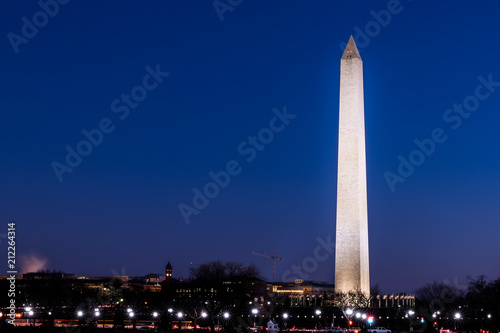 Tall high Washington Monument memorial in blue sky at evening night in winter  lawn  illuminated bright lights dark in December