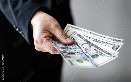Businessman giving (or paying) money,, US dollar bills - bribery, loan and financial concepts, Selective focus