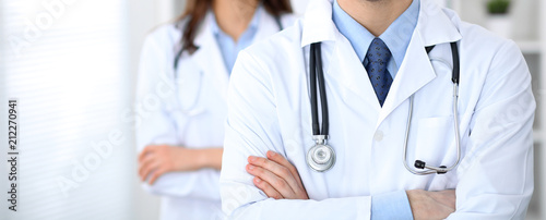 Groupe of unknown doctors standing straight in hospital office. Close Up of stethoscope at practitioner breast photo