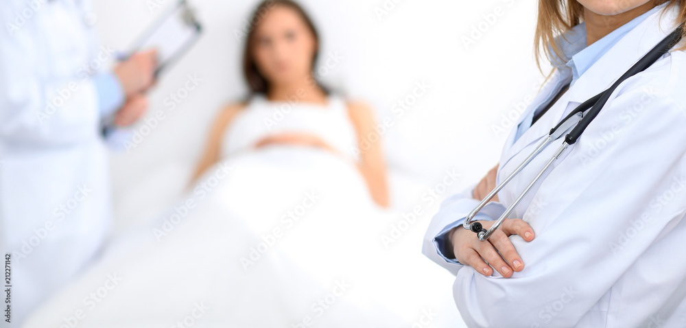 Female doctor standing straight in hospital. Closeup of stethoscope at practitioner breast. Medicine and health care concept Female doctor standing straight in hospital. Closeup of stethoscope at practitioner breast. Medicine and health care concept