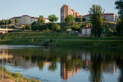 Sights and views of Grodno. Belorussia. River Neman flowing through the city. Sunset and reflection in the water of buildings on the shore.