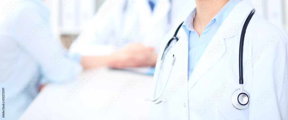 Unknown female doctor with medical staff at hospital. Teamwork in medicine Unknown female doctor with medical staff at hospital. Teamwork in medicine