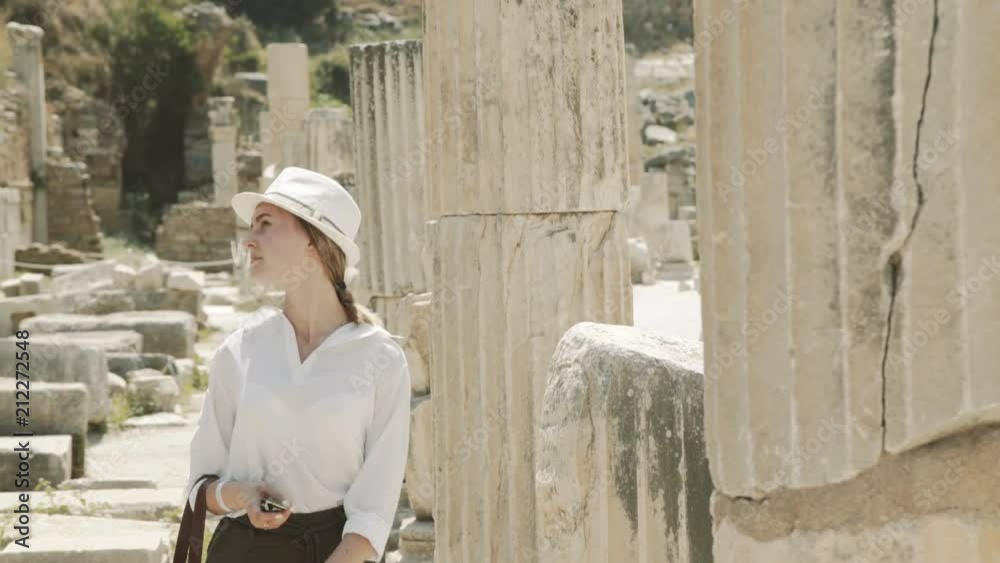 The young girl looking on and touching the ancient columns. 4K The young girl looking on and touching the ancient columns. 4K