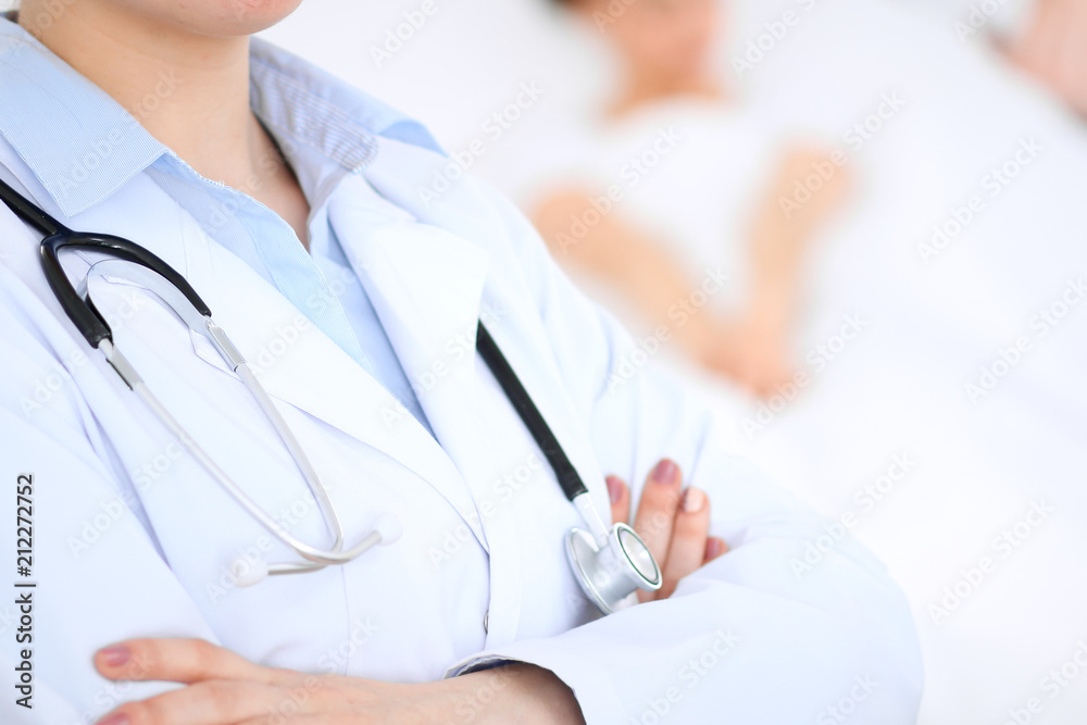 Unknown female doctor with medical staff at hospital. Closeup of stethoscope Unknown female doctor with medical staff at hospital. Closeup of stethoscope