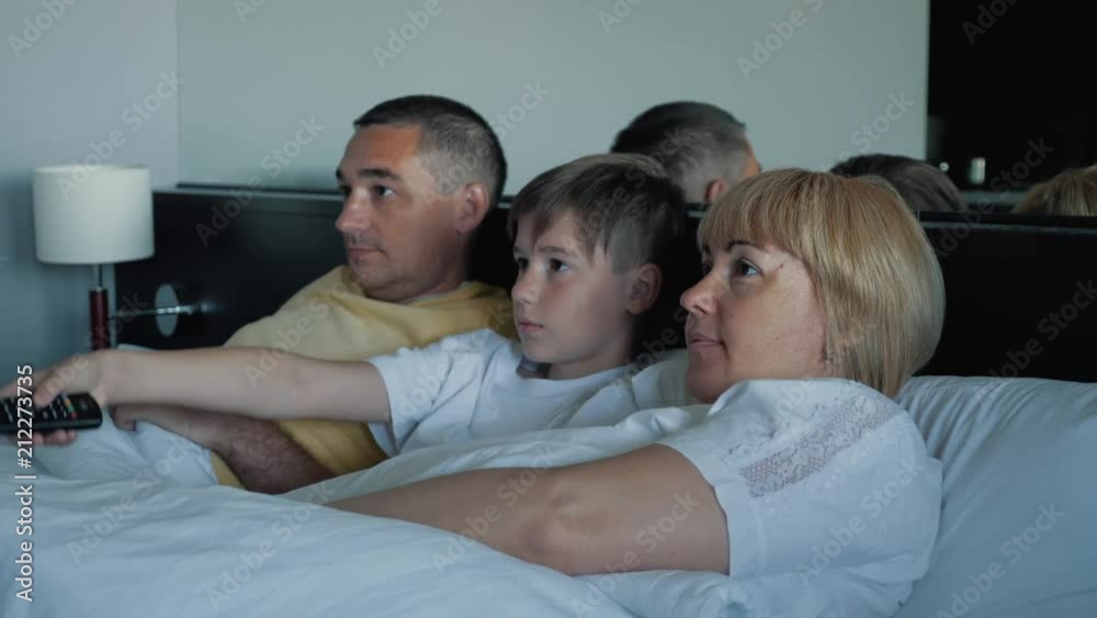 Happy family watching television together at home and laughing with pleasure together. Happy family watching television together at home and laughing with pleasure together.