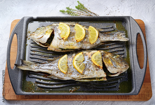 Grilled sea bream with lemon parsley and thyme. Orate alla griglia. Top view