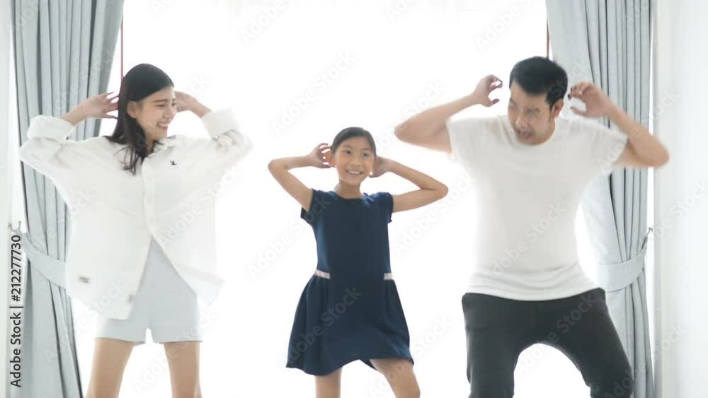 Happy young Asian family dancing together at home. Happy young Asian family dancing together at home.