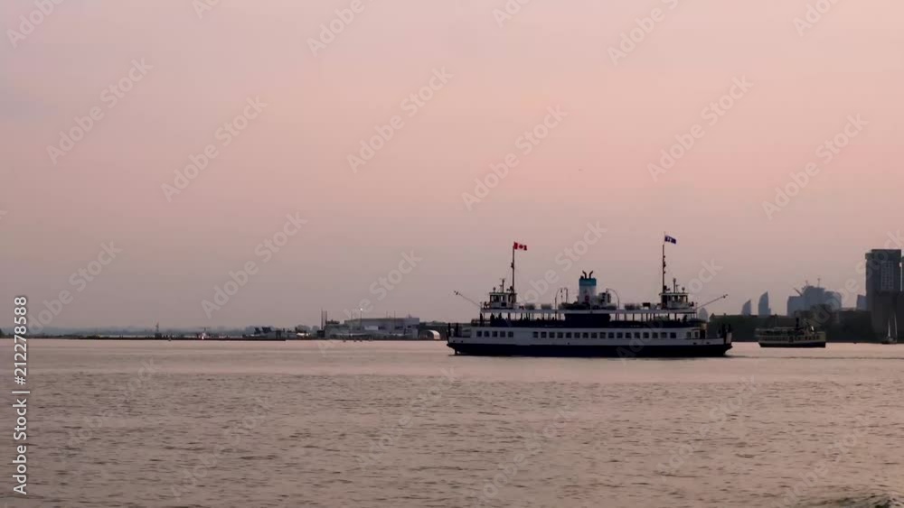 Mid shot of a ferry traveling across water at sunset in 4k, located on Lake Ontario just off of Toronto Mid shot of a ferry traveling across water at sunset in 4k, located on Lake Ontario just off of Toronto